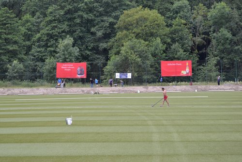 Während die Vereinsmitglieder den Boden neben dem Spielfeld abfrästen, verklebte ein Polytan-Mitarbeiter die Linien Während die Vereinsmitglieder den Boden neben dem Spielfeld abfrästen, verklebte ein Polytan-Mitarbeiter die Linien