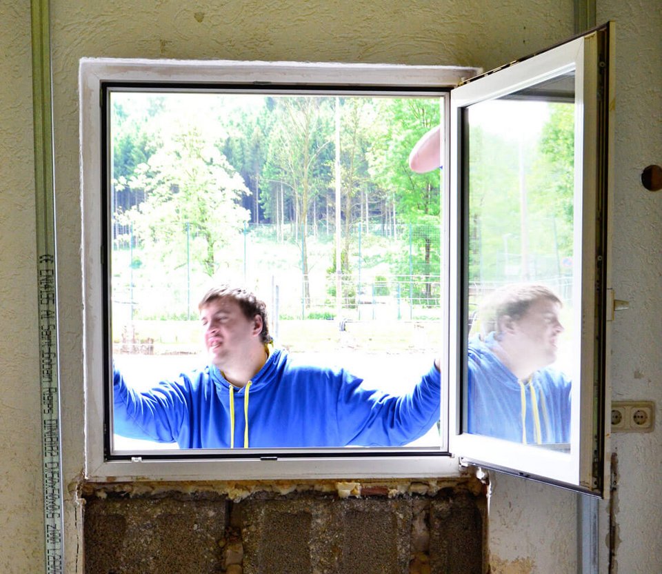 Carsten Fricke beim Ausbau eines Fensters in Vorbereitung zum Aufbau der neuen Durchgangstür