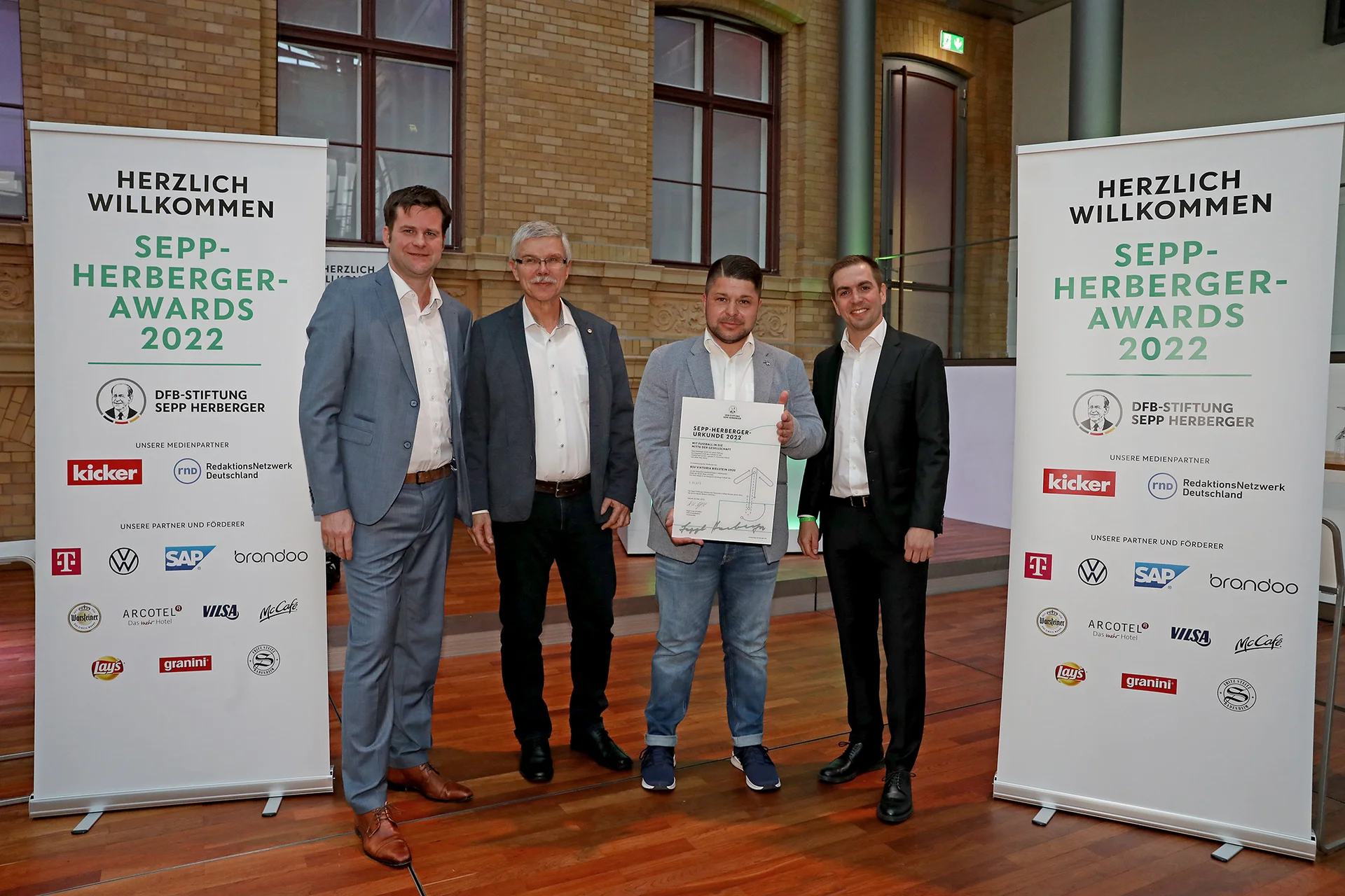 Christof Fries und Christopher Pethe nahmen den Sepp-Herberger-Preis 2022 in Silber aus den Händen von DFB-Vizepräsident Ralph-Uwe Schaffert und Ex-Fußballprofi Philipp Lahm entgegen (Foto: Carsten Kobow/DFB-Stiftung Sepp Herberger)