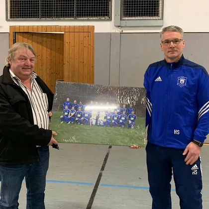 Trainer Holger Schulte (r.) und Sponsor Rüdiger Reidl (l.) bei der Übergabe eines Bilds der Mannschaft