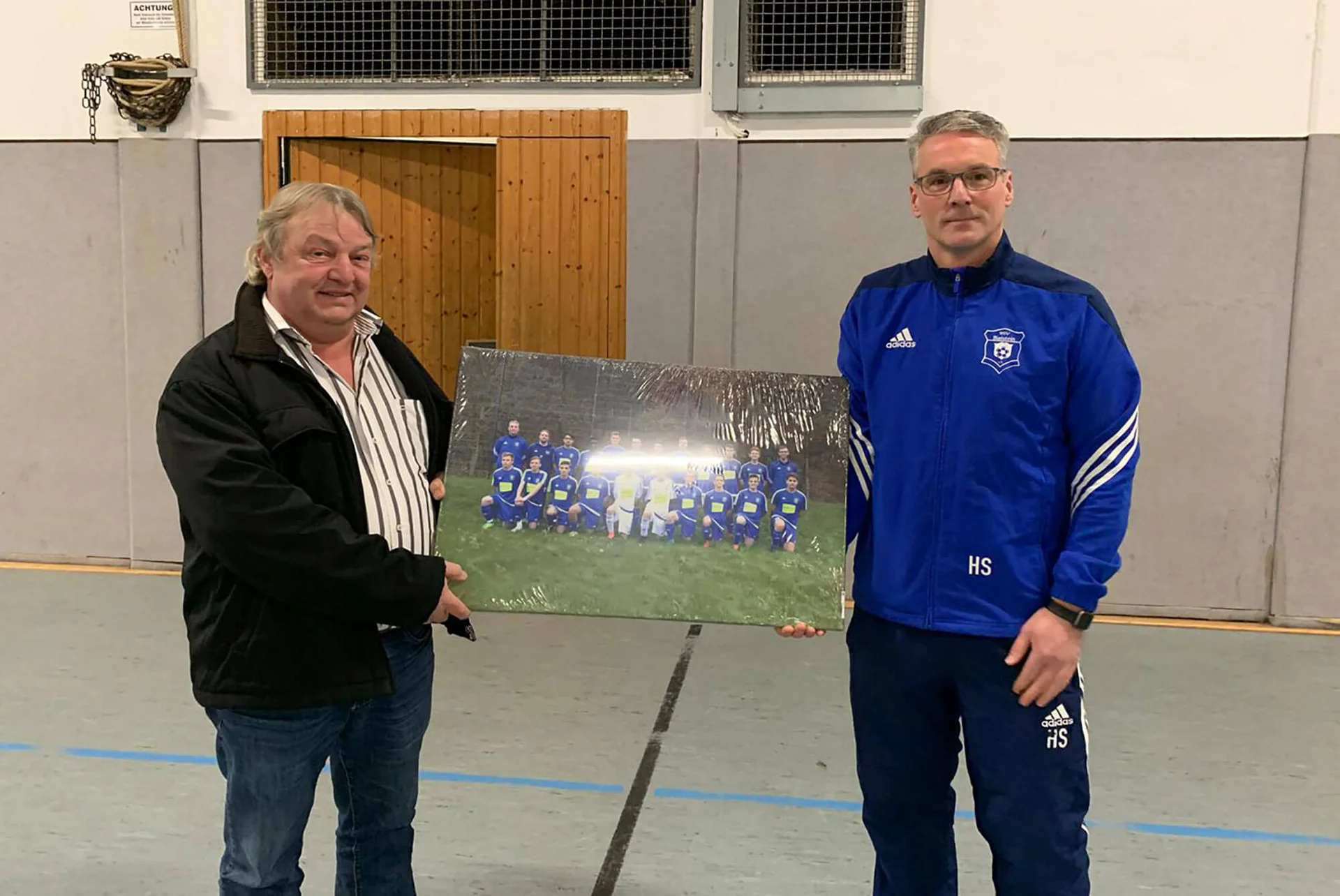 Trainer Holger Schulte (r.) und Sponsor Rüdiger Reidl (l.) bei der Übergabe eines Bilds der Mannschaft