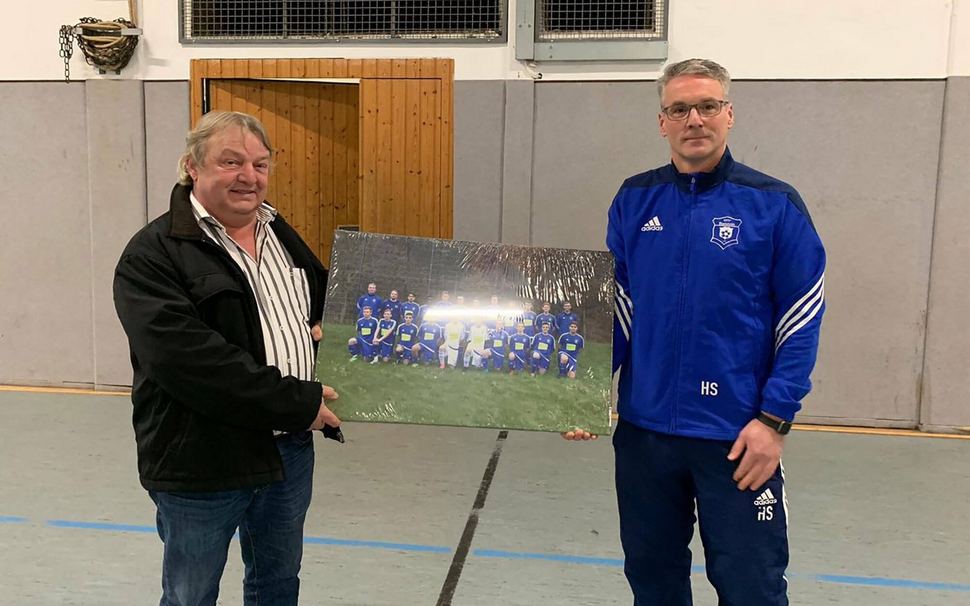 Trainer Holger Schulte (r.) und Sponsor Rüdiger Reidl (l.) bei der Übergabe eines Bilds der Mannschaft